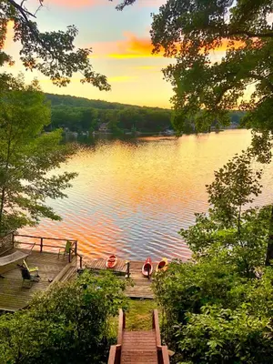 a dock with two boats on a lake at sunset at Villa Adriana 4bdr 2 bath lake front dream home in Vernon