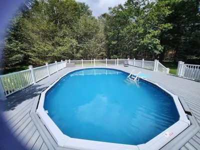 a large swimming pool on a wooden deck at Cozy 4 Bedrooms Pool Game Room in Tobyhanna