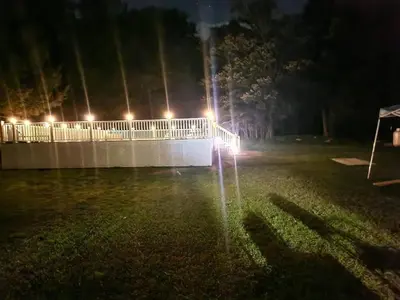a fence with lights in the grass at night at Cozy 4 Bedrooms Pool Game Room in Tobyhanna