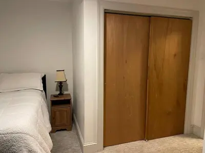 a bedroom with a bed and a wooden door at Fantastic updated apartment with parking in Glenside