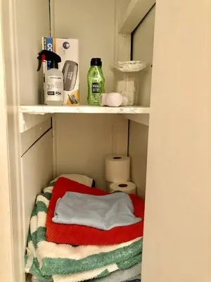 a closet with a red and white towel on a shelf at Fantastic updated apartment with parking in Glenside
