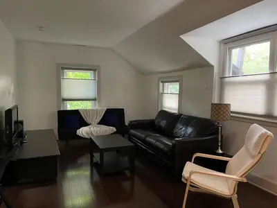 a living room with a black leather couch and chairs at Fantastic updated apartment with parking in Glenside