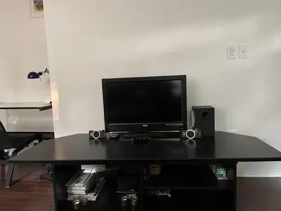 a black table with a television and speakers on it at Fantastic updated apartment with parking in Glenside