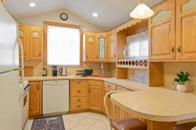 a kitchen with wooden cabinets and a white refrigerator at All-American classic,18 min to Manhattan in Carlstadt