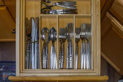 a wooden cabinet filled with silver utensils at Classic American-style, 18 min to NYC in Carlstadt