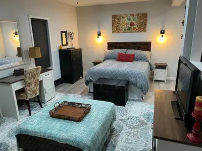 a bedroom with two beds and a desk and a television at Cozy Studio Apartment in Montgomery