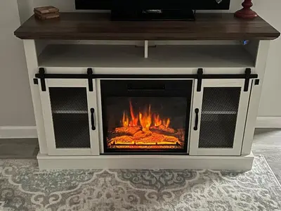 a fireplace in a living room with a fire in it at Cozy Studio Apartment in Montgomery