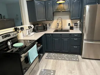 a kitchen with blue cabinets and a stove top oven at Cozy Studio Apartment in Montgomery