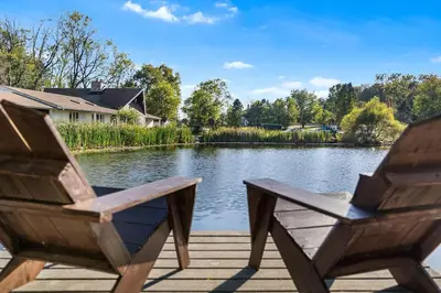 two chairs sitting on a dock next to a lake at Pond Haven Retreat Wood-Burning HotTub & FirePit in Mount Bethel