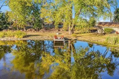 a table and chairs sitting on top of a pond at Pond Haven Retreat Wood-Burning HotTub & FirePit in Mount Bethel