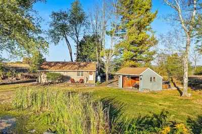 a cottage in the middle of a yard at Pond Haven Retreat Wood-Burning HotTub & FirePit in Mount Bethel