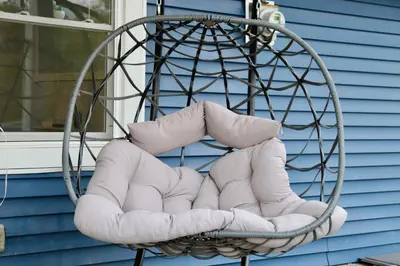 a wicker chair with pillows on a porch at Modern Lakeview Escape | Scenic Deck • Fire Pit in Monroe