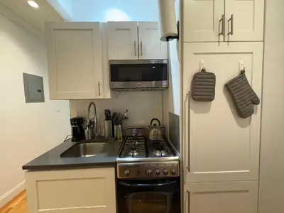 a small kitchen with a stove and a sink at Signature by Times Square in New York