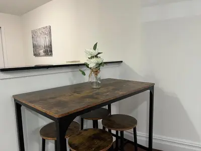 a table with chairs and a vase with flowers on it at Parkline Suites Upper West Side in New York
