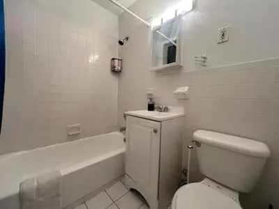 a bathroom with a toilet and a tub and a sink at Parkline Suites Upper West Side in New York