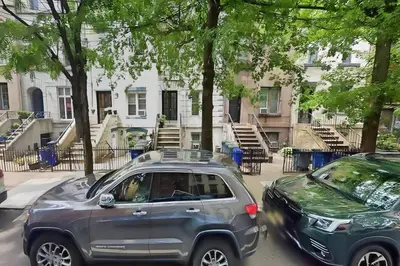 two cars parked on a street in front of buildings at PATHside 1BR Quick Access to NYC in Hoboken