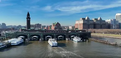 a bridge over a river with boats in a city at PATHside 1BR Quick Access to NYC in Hoboken