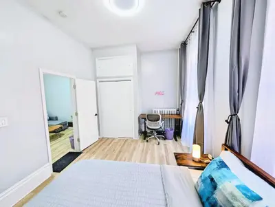 a white bedroom with a bed and a desk at PATHside 1BR Quick Access to NYC in Hoboken