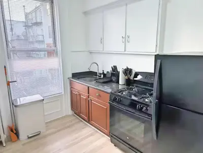 a kitchen with a stove and a black refrigerator at PATHside 1BR Quick Access to NYC in Hoboken