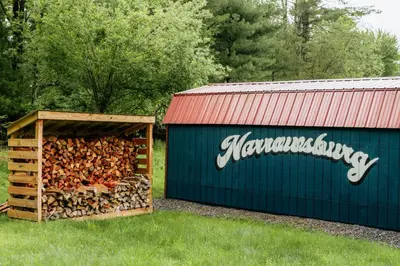 a pile of fire wood next to a building at Mural Art Cabin With Pond And Hot Tub in Narrowsburg