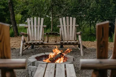 two chairs sitting around a fire in a fire pit at Mural Art Cabin With Pond And Hot Tub in Narrowsburg