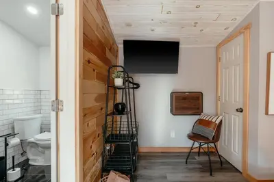 a bathroom with a staircase and a television on the wall at Mural Art Cabin With Pond And Hot Tub in Narrowsburg