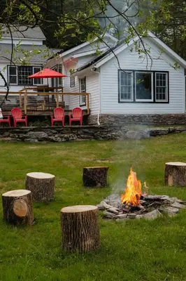 a fire pit in a yard in front of a house at Waterfront 1900s Hot Tub Eldred Homestead in Eldred