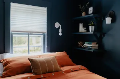a blue bedroom with a bed and a window at Waterfront 1900s Hot Tub Eldred Homestead in Eldred