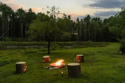 a fire pit in the middle of a field at Waterfront 1900s Hot Tub Eldred Homestead in Eldred