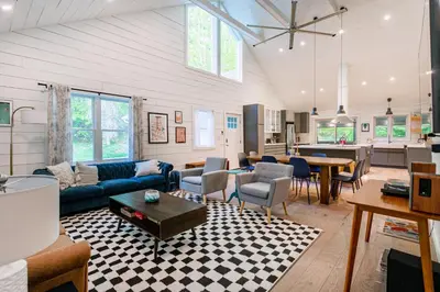 a living room with a couch and a table at Hare & Hollow with Hot Tub & Fenced Yard