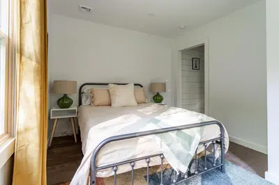 a bedroom with a bed and a mirror at Hare & Hollow with Hot Tub & Fenced Yard