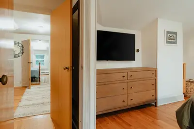 a bedroom with a dresser with a flat screen tv at Creekfront Cabin Sauna & Hot Tub Hikers Hollow in Cuddebackville