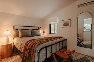 a bedroom with a bed and a chair and a mirror at Onyx Ridge Breathtaking Views 14 Acres in Jeffersonville