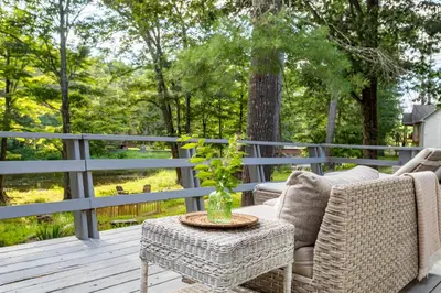 a patio with two chairs and a table on a deck at Riverfront Retreat Hot Tub, Firepit & Pool Table in Cuddebackville