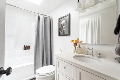 a white bathroom with a sink and a toilet at Riverfront Retreat Hot Tub, Firepit & Pool Table in Cuddebackville