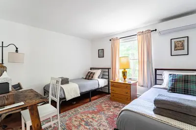 a bedroom with two beds and a desk at Riverfront Retreat Hot Tub, Firepit & Pool Table in Cuddebackville