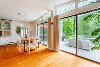 a dining room with a table and a large window at Riverfront Retreat Hot Tub, Firepit & Pool Table in Cuddebackville