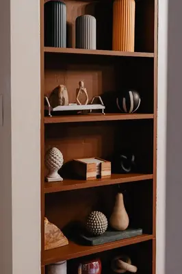 a book shelf filled with vases and other items at Rivers Ledge Cabin with Sauna and Hot Tub in Barryville