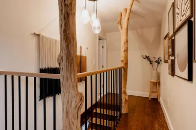 a staircase in a house with a tree trunk at Rivers Ledge Cabin with Sauna and Hot Tub in Barryville