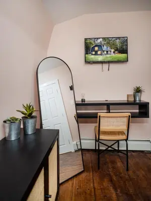 a mirror and a table and a chair in a room at Rivers Ledge Cabin with Sauna and Hot Tub in Barryville
