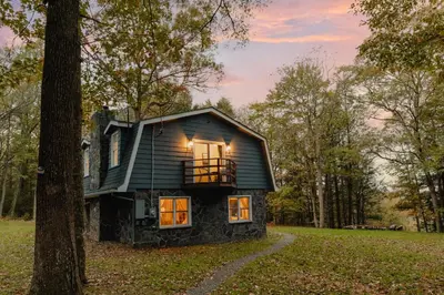a small house in the middle of a forest at Rivers Ledge Cabin with Sauna and Hot Tub in Barryville