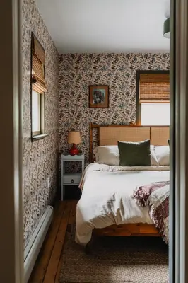 a bedroom with a bed with floral wallpaper at Roebling House 1850s Cabin Hot Tub Fire Pit in Barryville