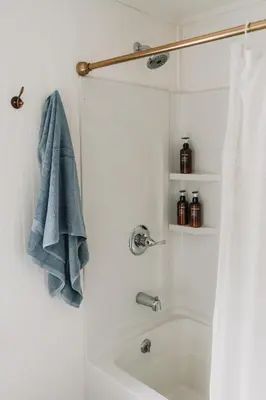 a bathroom with a shower with a blue towel at Roebling House 1850s Cabin Hot Tub Fire Pit in Barryville