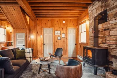 a living room with a couch and a fireplace at Breathtaking River Views The Hawks Nest Cabin in Glen Spey