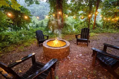 a fire pit in the middle of two park benches at Breathtaking River Views The Hawks Nest Cabin in Glen Spey