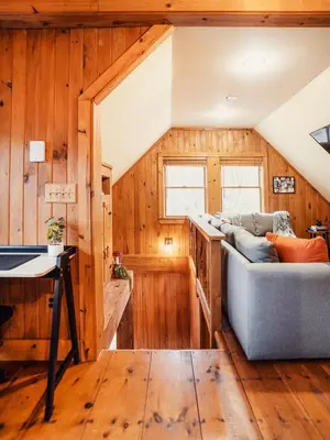 a living room with wooden walls and a couch at Breathtaking River Views The Hawks Nest Cabin in Glen Spey