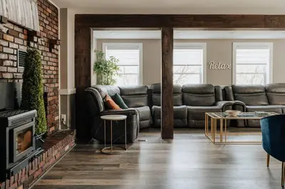 a living room with leather couches and a fireplace at Swan Pond Cabin Hot Tub & Firepit Retreat in Swan Lake