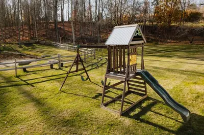 a playground with a slide in the grass at Swan Pond Cabin Hot Tub & Firepit Retreat in Swan Lake