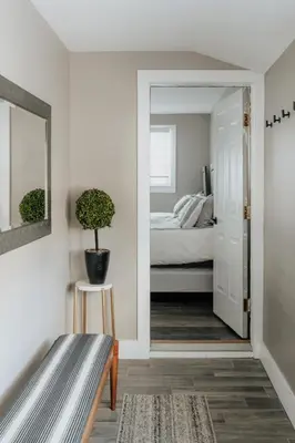a bedroom with a bed and a mirror and a bench at Swan Pond Cabin Hot Tub & Firepit Retreat in Swan Lake