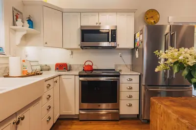 a kitchen with stainless steel appliances and white cabinets at Secluded Charming Farmhouse Lake Views Firepit in Narrowsburg